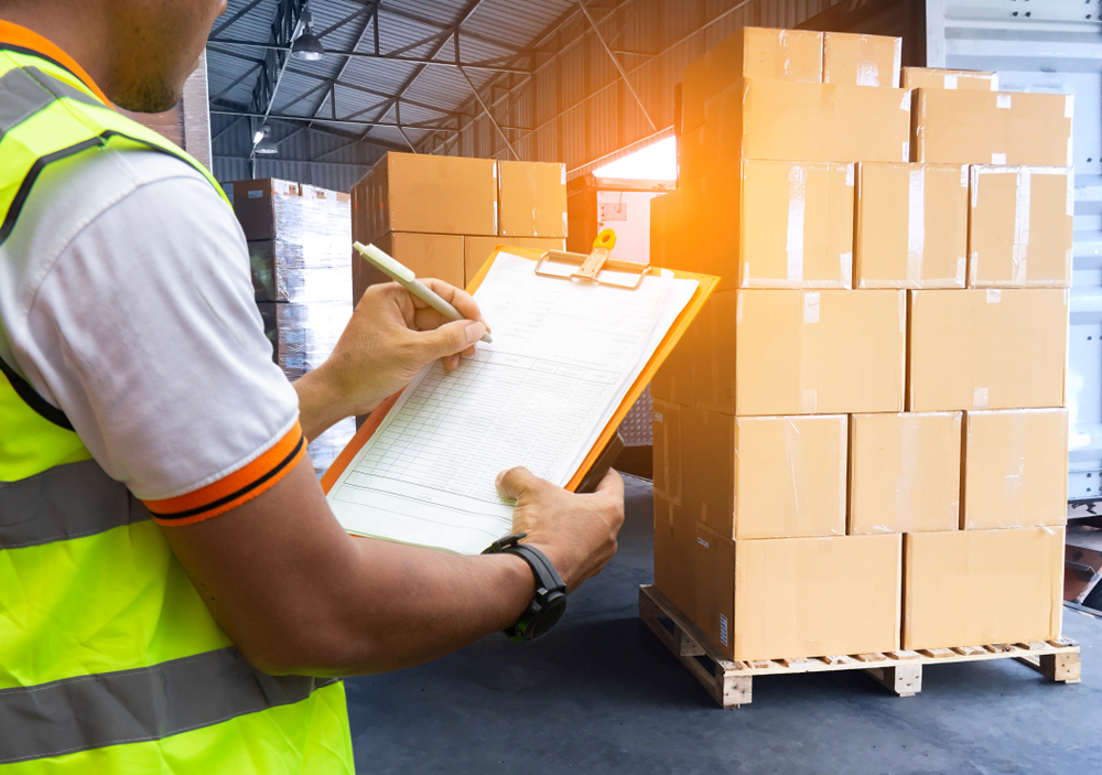 Worker,Courier,Holding,Clipboard,His,Control,Loading,Package,Boxes,Into