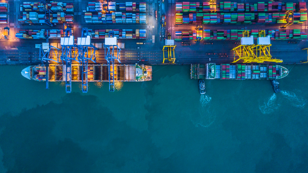 Container ship loading and unloading in deep sea port, Aerial view business commercial trading logistic import and export sea freight transportation, Container loading cargo freight ship maritime at night
